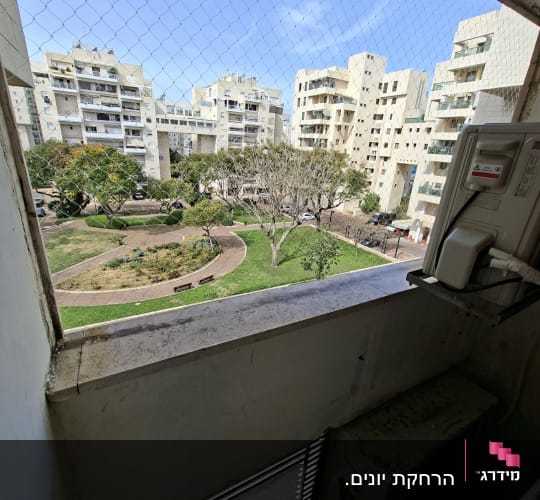 רשת יונים מותקנת על מרפסת עם נוף לבניינים